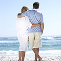 A couple at retirement age standing on a beach
