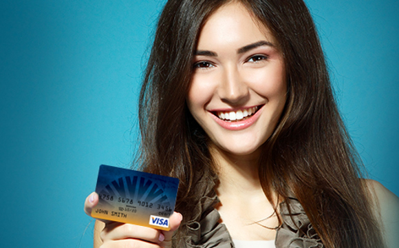 A smiling women holding a Goldenwest reloadable card.