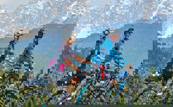 A couple riding their E-Bikes in the mountains.