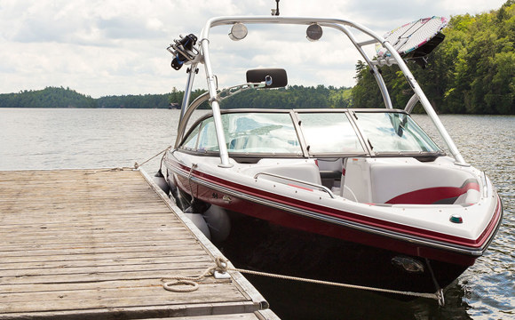 A boat tied to a lake dock.
