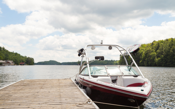A boat tied to a lake dock.