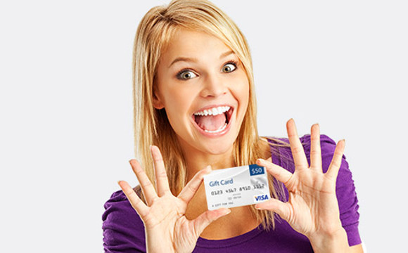 A smiling women showing off her gift card.
