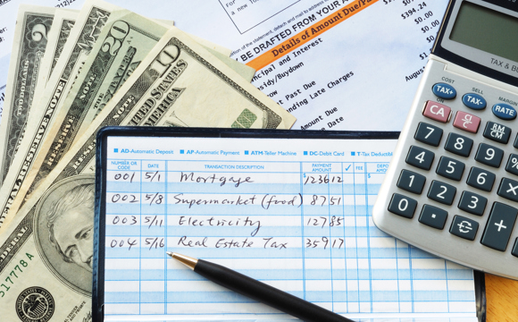 A closeup of a calculator and a handwritten check balancing ledger.