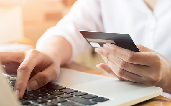 A close up of a debit card held by a man in a suit.