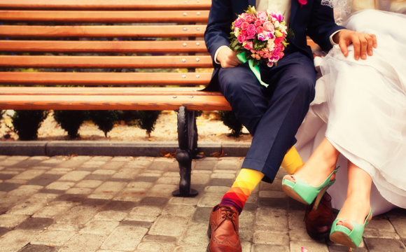 Newly wedded couple sitting on a bench.